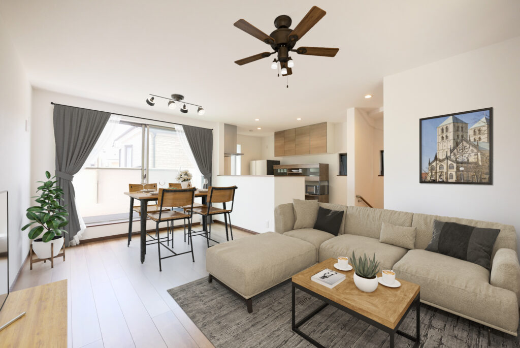 LDKのCGホームステージングイメージ。ベージュのL字ソファ・木天板のセンターテーブル・アイアン脚のダイニングセット4人掛け・シーリングファンライト・スポットライト・グレーのカーテン・観葉植物・壁掛けアートなどをCGで配置し、実際の生活シーンをイメージできるよう演出している