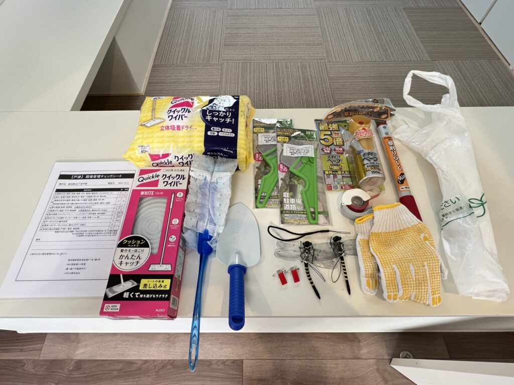 戸建て現場管理用の掃除道具一式：クイックルワイパー本体と立体吸着ドライシート、ハンディモップ、移植ゴテ、結束バンド付きクリップ、養生テープ、草刈りバサミ、ベープ虫除けスプレー、軍手、レジ袋、現場管理チェックシート