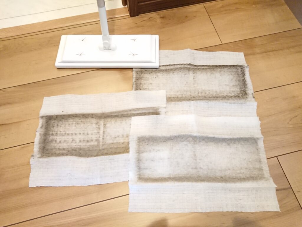 現場管理で室内清掃した後のクイックルワイパーと使用済みドライシート3枚。シートにはホコリや汚れがしっかり付着しており、空き家でも定期清掃が必要なことがわかる